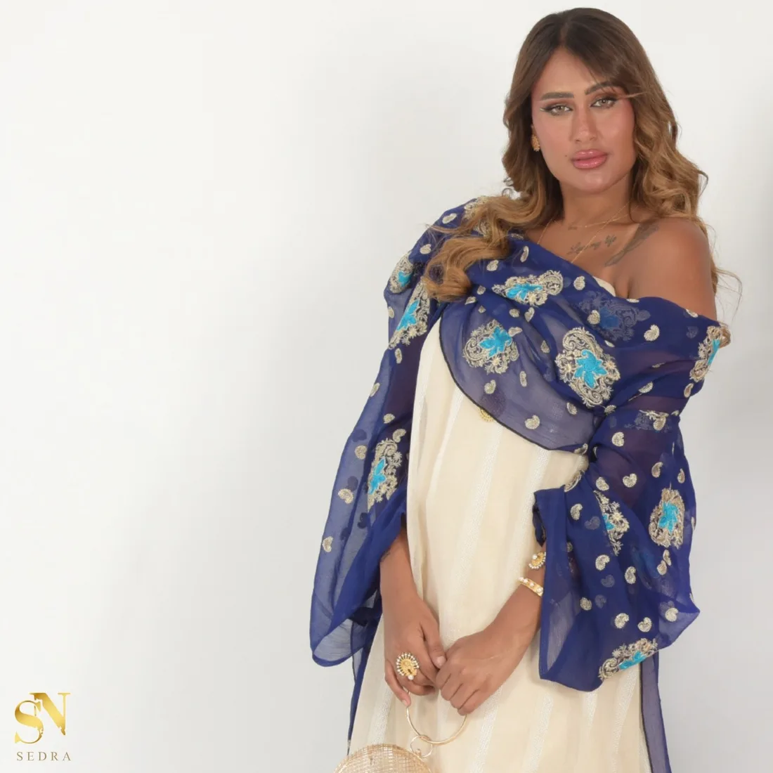 جلابية كريمية مع شال كحلي مطرّز بالفيروزي والذهبي