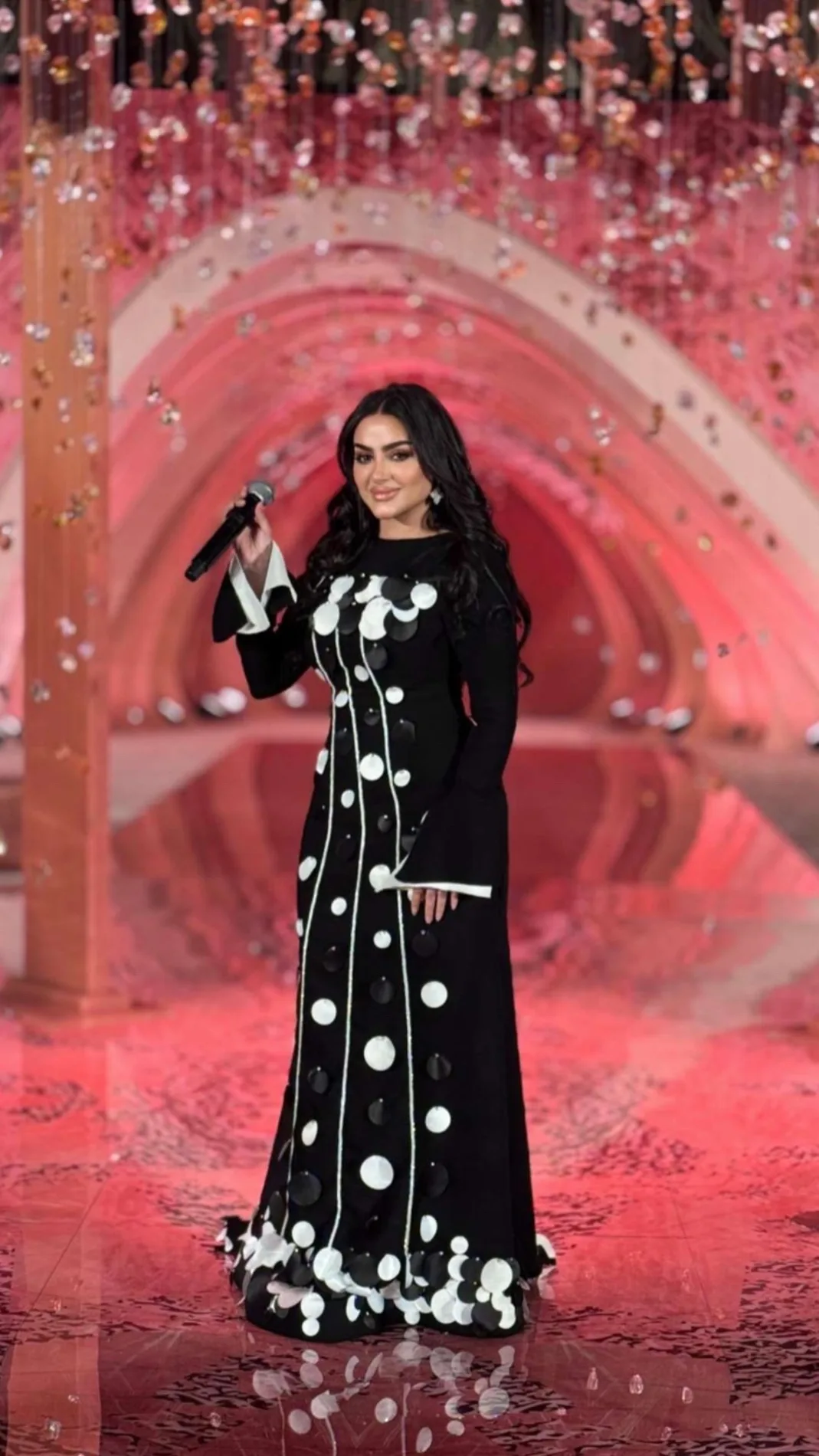فستان أسود طويل بأكمام واسعة مزيّن بدوائر من الساتان الأبيض والأسود